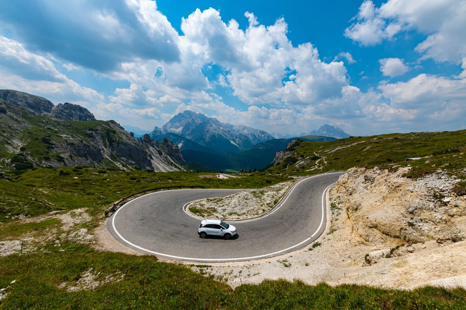 A narrow mountain road curving along a steep hillside in Italy